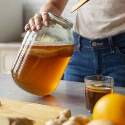 front-view-woman-preparing-kombucha